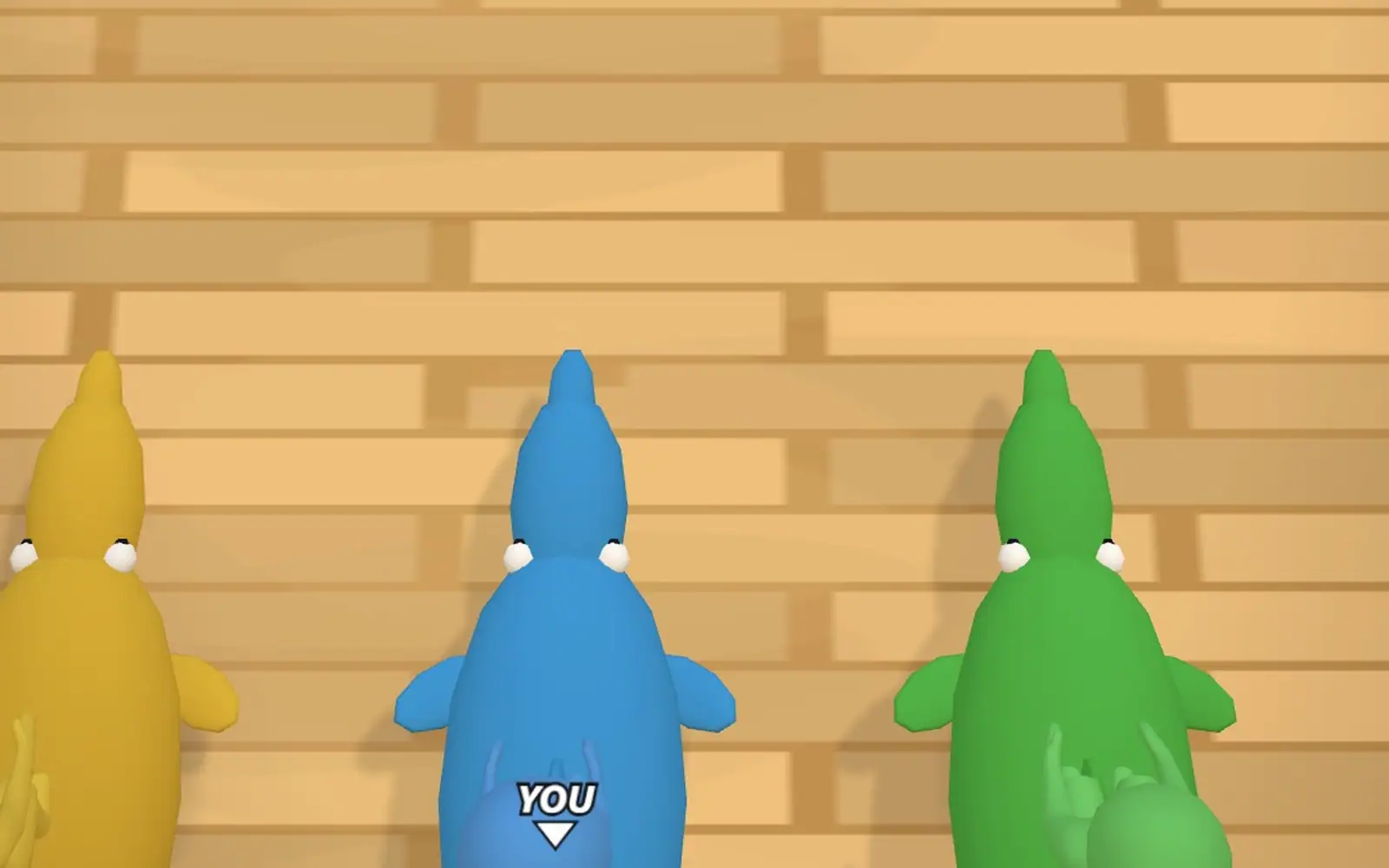 Three characters lined up against a wooden wall, the blue one in the middle tagged YOU.