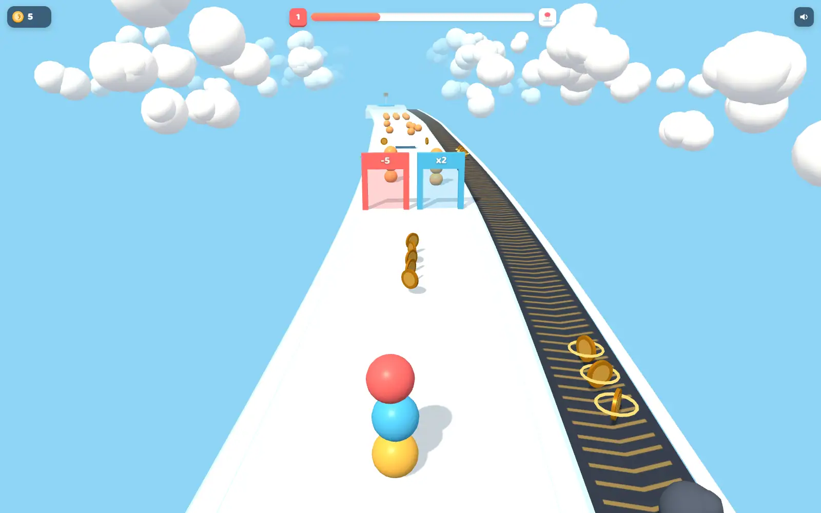 A stack of coloured balls rolling along a white lane, coins ahead and a conveyor running alongside.